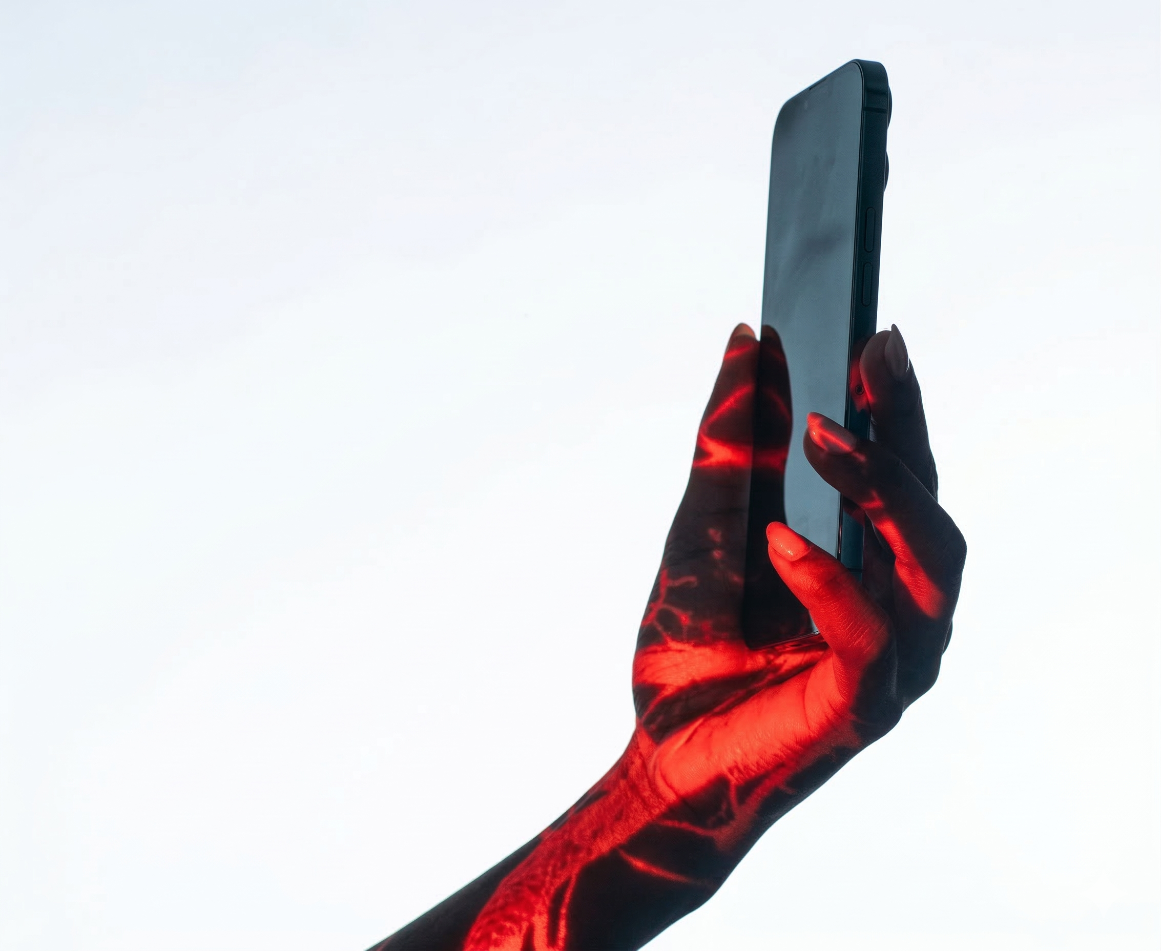 Kakoo preview image showing a hand holding a smartphone against a bright background with vivid red reflections.
